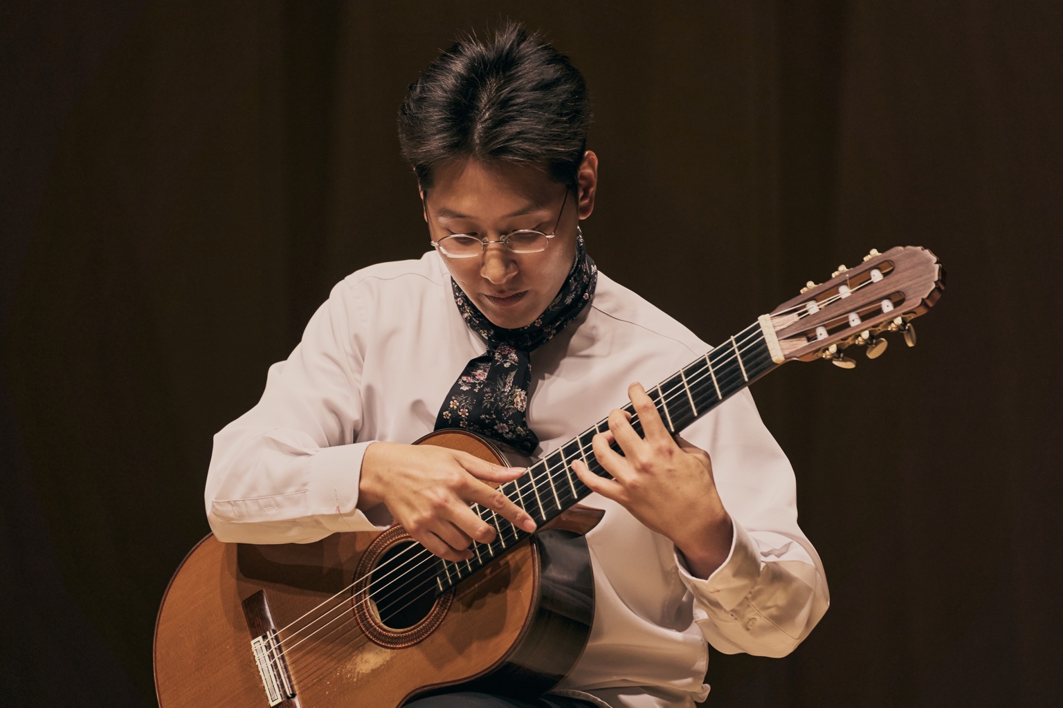 Seungsu Shin performing with both hands on the guitar fingerboard