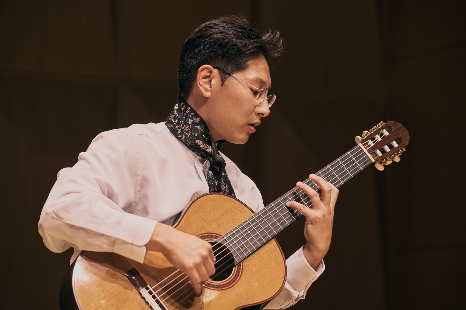 Seungsu Shin playing classical guitar on stage