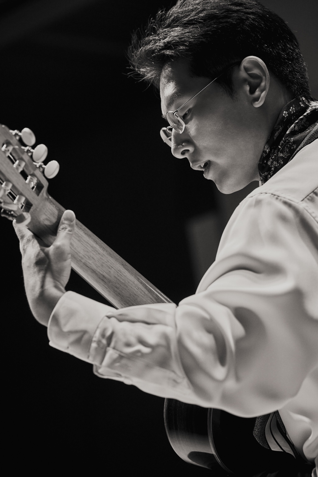 Black-and-white close-up of Seungsu Shin playing guitar